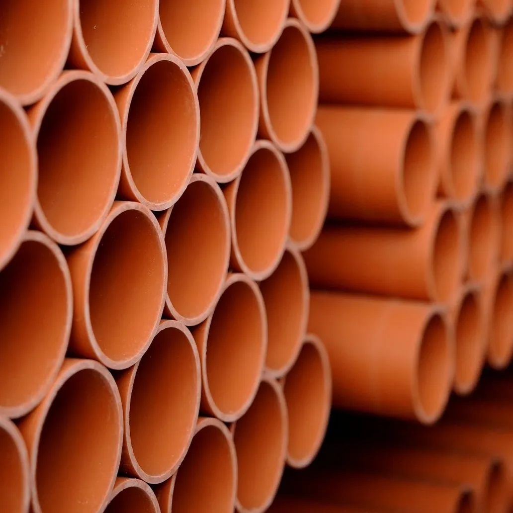 Stos tulei PCW Drewplast, prezentujący precyzyjnie cięte rury o gładkim, trwałym wykończeniu.